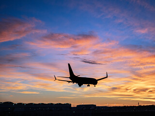 Passenger airliner landing at Seville Airport during sunset