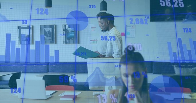 Reviewing teal folder, two men in shirts checking charts on wall display at office table