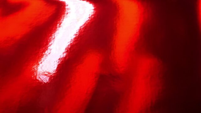 red lacquer texture with light reflections.Red festive background. Christmas and New Year wallpaper.holiday card background