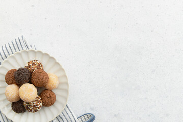 Typical Brazilian sweet brigadeiro. A heap of assorted flavors of candies on a white table with...