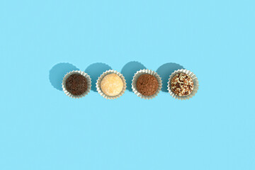 Typical Brazilian sweet brigadeiro. Assorted flavors of candies in a line on a blue background