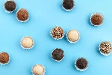 Typical Brazilian sweet brigadeiro. Assorted flavors of candies in a line on a blue background