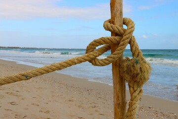 na plaży wbity pal i na nim uwiązana lina. © Pawel Zabczyk