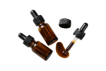 Amber glass dropper bottles, one spills serum