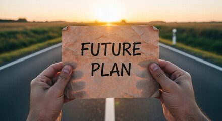 A person holding a sign with the words 'Future Plan' on a road at sunset representing the path to