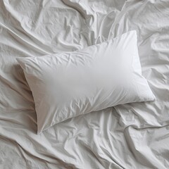 Obraz premium White pillow rests on wrinkled white sheets, viewed from above