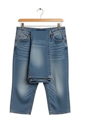 A pair of light blue denim pants hangs on a wooden hanger against a clean white background