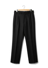 Black tailored trousers with pleats hanging on a clothes hanger with wooden and metal elements against a white background