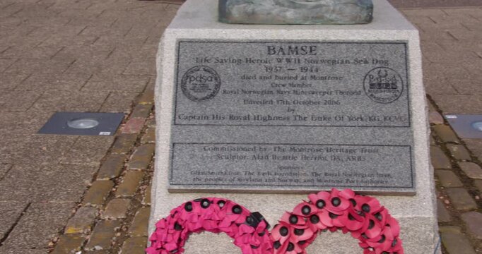 Mid panning shot of the plaque at the base of the statue of Bamse, Norwegian sea dog