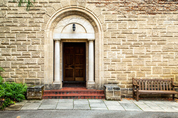 Wooden door and brick steps in old stone building.