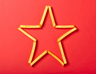 Fototapeta premium Star Shape Made with French Fries on Red Background