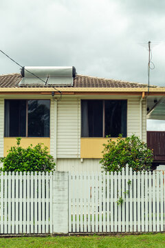 Rain and storm clouds and suburban house with solar hot water heater.