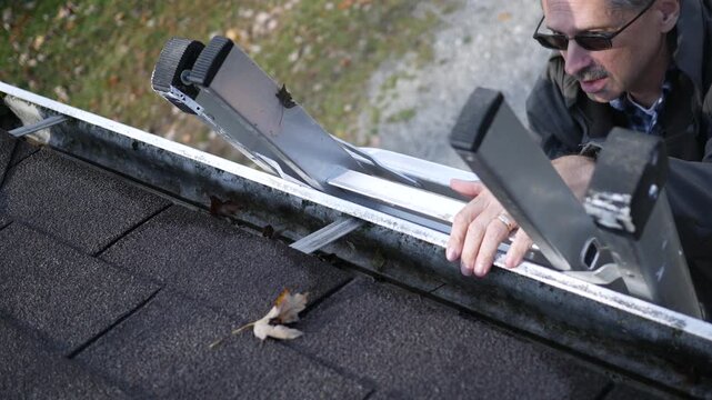 Older Man or Contractor Sets Ladder on Roof