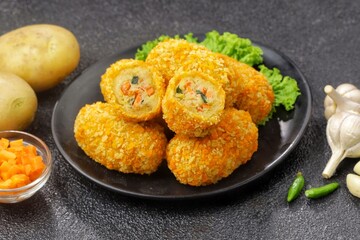 Kroket kentang. Croquettes are lumps of finely mashed potatoes filled with seasoned minced meat and mixed with vegetables such as carrots or green beans. The croquettes are coated with beaten egg and 