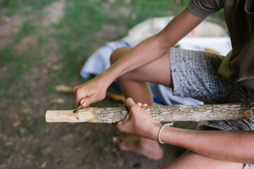 Child's hands carving the end of a stick