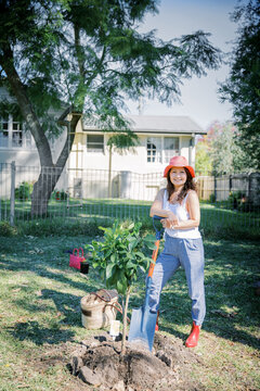 Asian woman planting a tree in garden