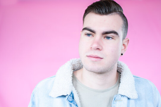 Portrait of young man on plain pink background