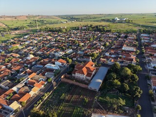 Aereal view  of a town with red tiled roofs and green fields in the distance