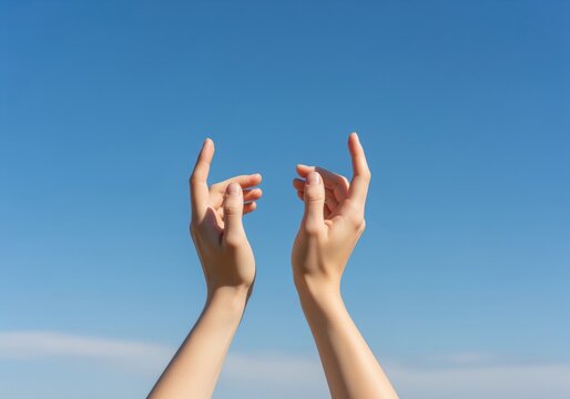 Hands reaching up to the clear blue sky, symbolizing hope and freedom