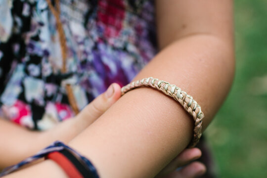 Close-up on a woven bracelet on a childs arm.