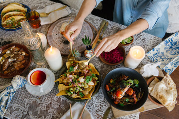 Top-down view of a table with various dishes and people eating.