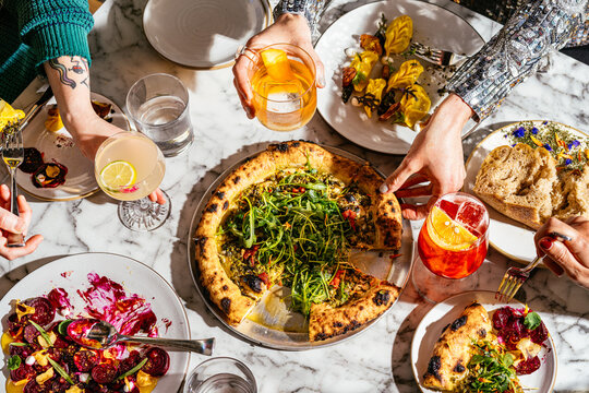 Restaurant Action Scene with Pizza, Pasta, Hands with Jewelry and cocktails