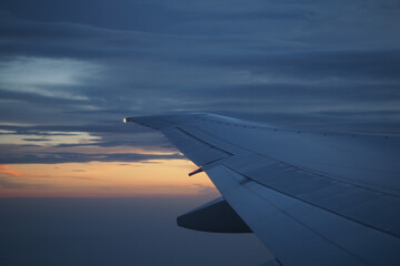Beautiful sunset over clouds seen from airplane wing