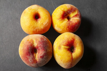 Four ripe peaches on dark background