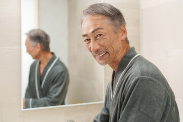 洗面所にいる笑顔のシニア男性