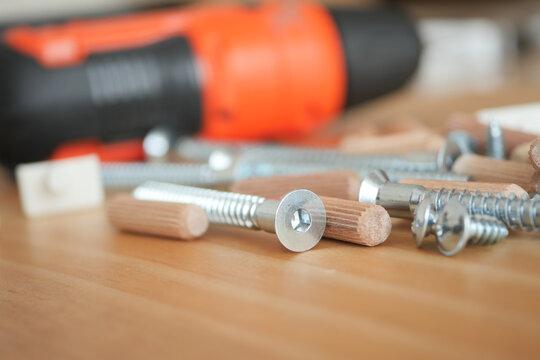 Tools and screws on wooden surface ready for assembly - Powered by Adobe