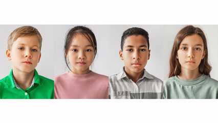 Four serious preteen children of diverse backgrounds stand in front of a white background. They gaze directly at the camera, showcasing friendship and unity in a studio setting.