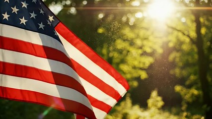 An American flag waves gently with the sun shining through green trees in the background - Powered by Adobe