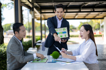 Business colleagues discussing sustainability during outdoor meeting presentation