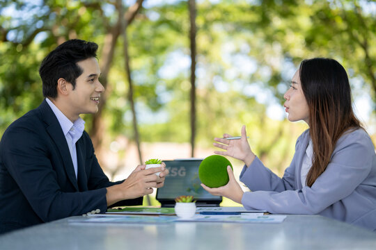 Business people discussing esg sustainability in green outdoor meeting
