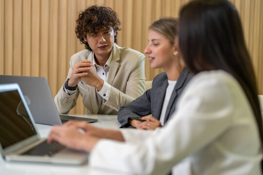 Diverse tech team meeting on software project, mentor guiding coworker on laptop, teamwork development using collaboration tools, modern technology, app design, dev training and enterprise SaaS team