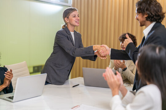 Multiracial team collaborating in modern office, diverse colleagues shaking hands during a business meeting, teamwork success, partnership agreement, professional collaboration multicultural workplace