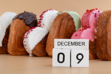 Calendar date 9 December National pastry day greeting card Delicious fresh croissant topped with colorful flavor Ganache. Creation unique heart shape bakery. Puff pastry holiday love gift present idea
