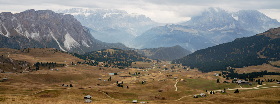 Beautiful autumn landscape at Seiser Alm (Alpe di Siusi) with Langkofel mountain range under cloudy sky in the Dolomites, Italy.