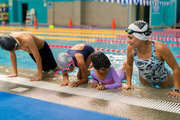 Swimming instructor teaching children water safety skills at pool