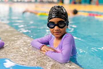 Young girl learning swimming at pool lesson