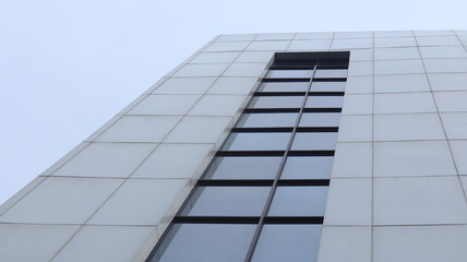 The square-shaped glass windows of a multi-storey building are arranged neatly and beautifully.