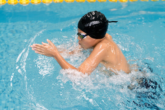 Boy practicing breaststroke during a swimming lesson