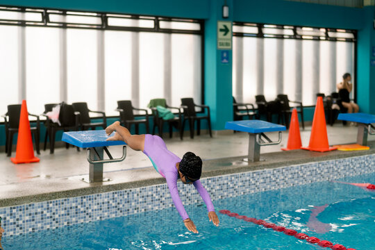 Child learning diving technique during swimming lesson