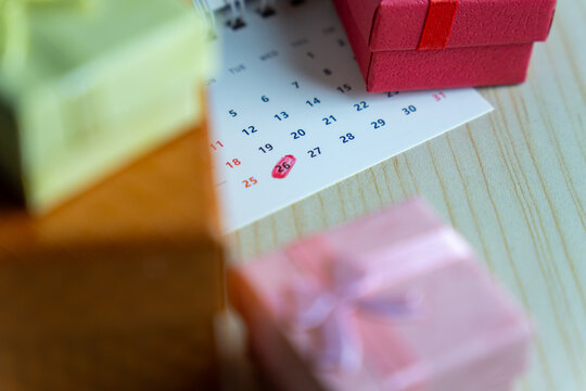 Close-up of a calendar with the 26th date circled in red surrounded by colorful gift boxes. Boxing Day celebration and post-holiday sales concept.