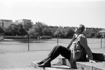 Senior man relaxing by the river in black and white analog film style