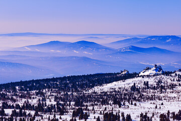 Mountain ridges in soft fog at dawn. Beautiful lilac blue Peaks fades into distance, pastel colored sky background. Minimal Nature abstract landscape, natural gradient color skyline, winter serenity.