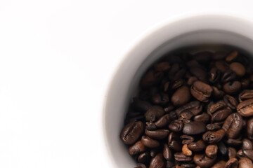coffee beans falling out of a white cup