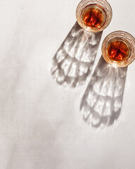 Whiskey Glasses with Shadows and sunlight Reflection on beige background, minimal aesthetic top...