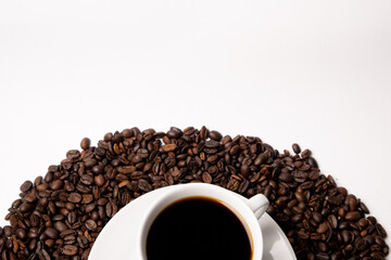 Cup with hot coffee and coffee beans below on a white background