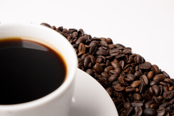 Cup with hot coffee and coffee beans below on a white background